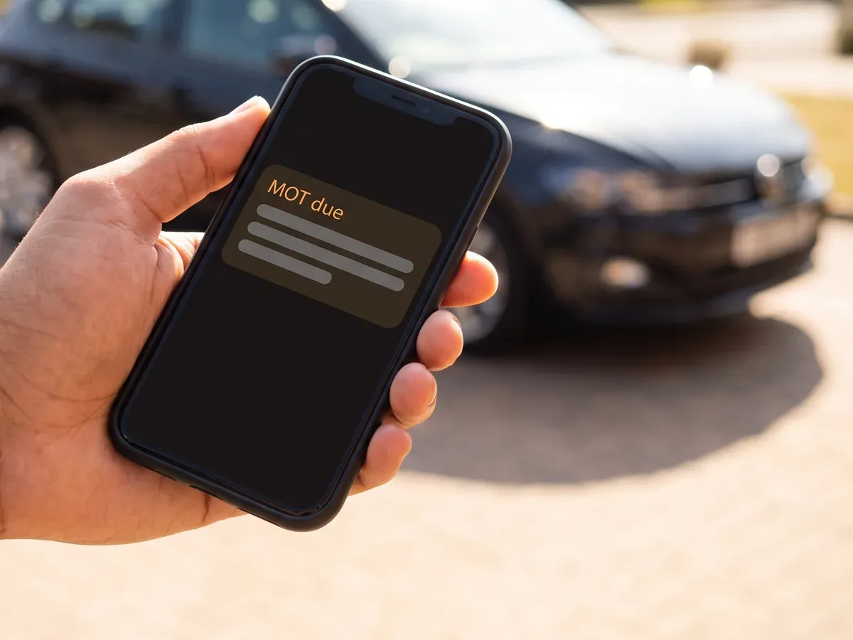 A phone showing an MOT reminder arriving before the date is due.