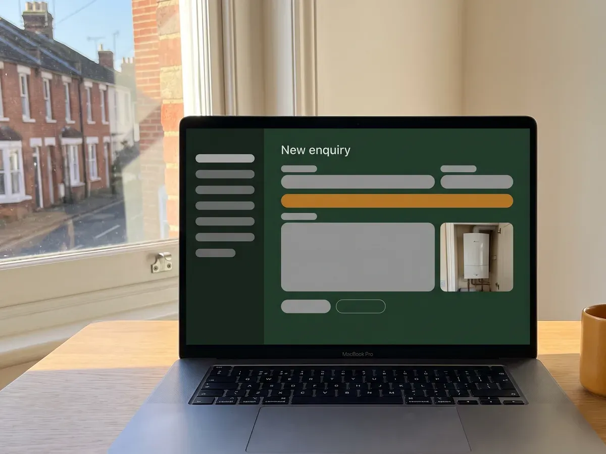 A boiler enquiry open in the back office on a laptop, with the customer's photograph of the boiler attached.